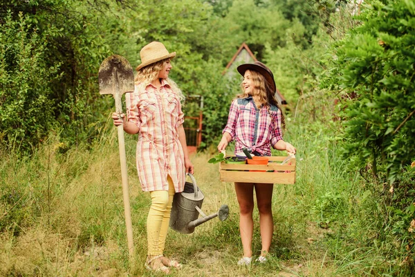 Hermosas floristas femeninas. Día de la Tierra. granja familiar de verano. Niñas granjeras en la aldea. agricultura y agricultura. lado del campo de primavera. niños sostienen herramientas de jardinería. ecología y protección de la naturaleza —  Fotos de Stock