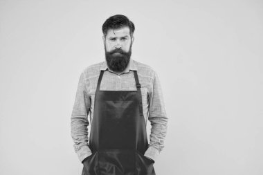 Sarı arka planda kırmızı önlüklü ciddi bir adam. Kendine güvenen ifade. Yakışıklı erkek barista çalışıyor. Olgun bir barmen. Yeni işini. Tezgahtar üniformalı adam. Boşluğu kopyala