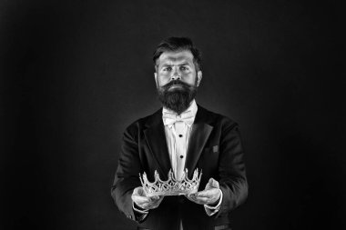 Reputation and status. Glory and ambitions. King crown. Royal coronation symbol. Now come and make it worth. Crown in hands. Handsome man give crown black background. Getting reward. Crowning glory clipart