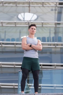 Spor eğitmenleri çevrimiçi. Mükemmel formda kasları olan güçlü bir atletik. Kulaklıkla müzik dinlerken egzersiz yapmak. Mola veriyorum. Tarz sahibi adam spor eğitimine hazır.