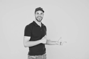 Profesyonel gülümseyen erkek çalışan. Gülümseyen teslimatçının portresi. Kırmızı üniformalı teslimatçı. İlk işi. Öğrenciler için yarı zamanlı bir iş. E-ticaret servisi. Boşluğu kopyala