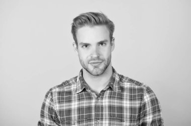 Sıradan tişörtlü bir adam. Yüzü kıllı yakışıklı adam. Erkek güzellik standardı. Sarı arka planda manken. Tıraşsız seksi adam. Kot giyim modası. berber salonu