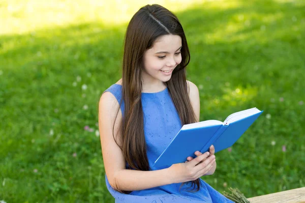 Kleines glückliches Mädchen liest Buch im Freien sonnigen Tag, cooles Story-Konzept — Stockfoto