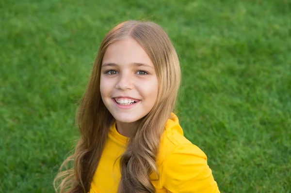 Glad leende liten flicka avkopplande grönt gräs, perfekt ålder koncept — Stockfoto