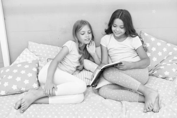 Libro sull'amore. Ragazze bambini giacevano letto letto letto libro. Piacevole momento in camera da letto accogliente. Ragazze sorelle pigiama carino rilassarsi e leggere il libro. Idee di isolamento per i bambini. Continua a studiare a casa. Favola preferita — Foto Stock