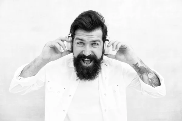 Concept sonore parfait. Hipster écouter de la musique casque stéréo. Casque sans fil moderne. Musique de danse électronique et pistes house. Musique instrumentale. Homme barbu casque arrière-plan lumineux — Photo