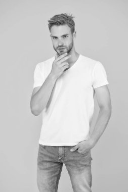 Yaz titreşimleri. Sarı arka plandaki seksi adam. Erkek güzellik stili. Karizmatik manken. Sıradan bir yaz kıyafeti. Genç ciddi öğrenci. Berber dükkanı konsepti. Tıraşsız, yakışıklı adam.