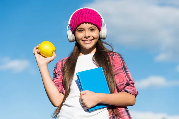 Natural alternative to dieting. Happy girl hold apple on blue sky. Fruit snack. Healthy eating habits. Dental diet. Preventive dentistry. Eating and dieting. Food that helps your brain study