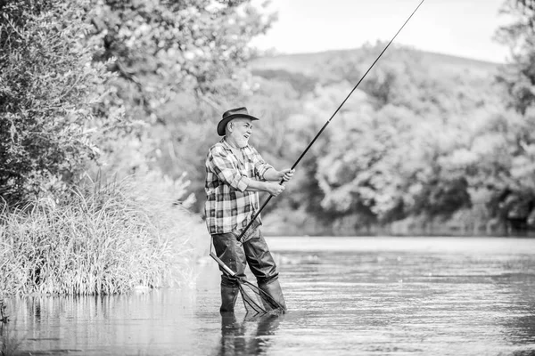 Starší muž rybaří. Mužský volný čas. Rybář s prutem. Štěstí je tyč v ruce. Rybář v důchodu. Starší muž chytá ryby. Aktivita a koníček. Rybaření sladkovodní jezero řeka — Stock fotografie