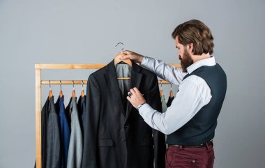O uzman bir terzi. Bireysel insan eli ölçer. Adam içeride iş elbisesi sipariş ediyor. Terzi ölçer adamım. Çalışma alanında şık bir iş adamı. Moda tasarım stüdyosu. Erkek moda tasarımcısı