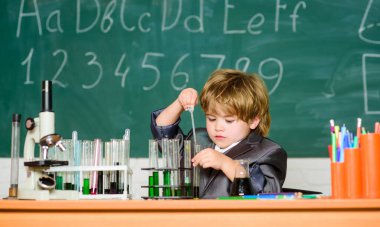 Büyüleyici bir konu. Bilgi toplama günü. Çocuk biyoloji kimyası okuyor. Temel bilgi ilkokul eğitimi. Eğitim deneyi. Erkek mikroskobu ve test tüpleri sınıfı. Bilgi kavramı