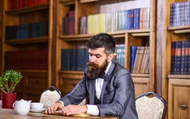 Orta yaşlı bir adam odada kahvaltı yapıyor.