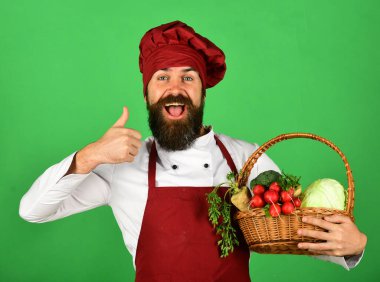 Sağlıklı aşçılık kavramı. Bordo üniformalı gülen yüzlü aşçı.