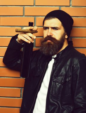 Sakallı, Kafkas hippisi elinde şişe, puro içiyor.