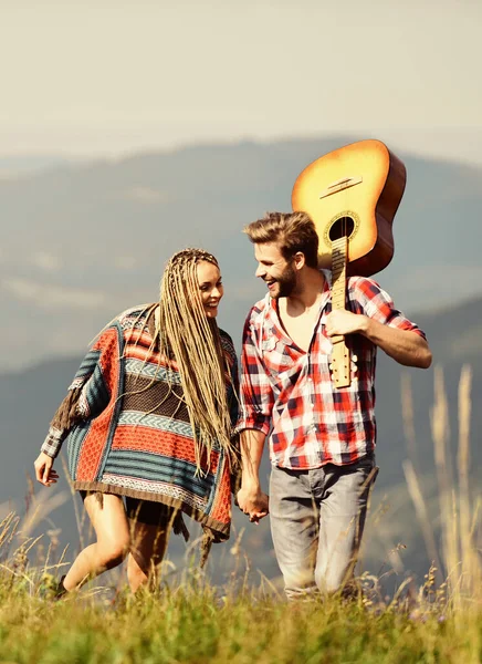 Cheerful couple. western camping. hiking. friendship. campfire songs. men play guitar for girl. happy friends with guitar. country music. romantic date. couple in love spend free time together