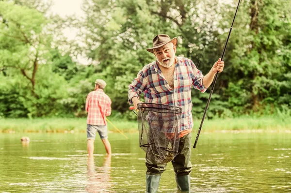 Fishing time. family bonding. summer weekend. two fishermen with fishing rods, selective focus. retired mature man fisher. hobby and sport activity. father and son fishing. male friendship — Stock Photo, Image