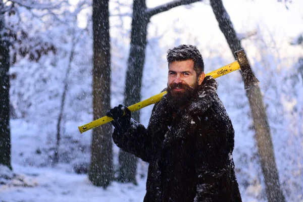 Macho med skägg och mustasch håller gul yxa. — Stockfoto