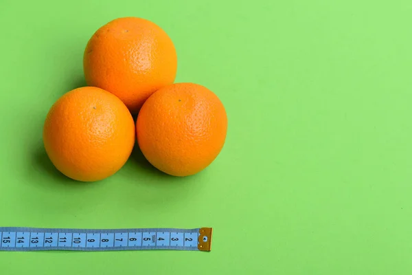 Modèle composé d'oranges près du ruban à mesurer en couleur cyan — Photo
