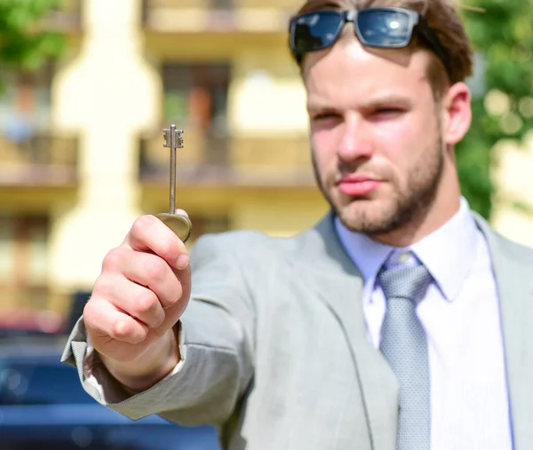 Makelaar heeft de sleutel tot het huis. Jongeman in de tuin — Stockfoto