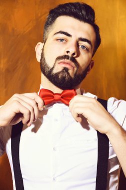 Stüdyo duvarında ciddi bir yüzü olan sakallı bir adam.