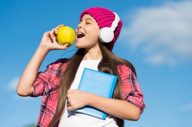 Temiz hava almak için ara verdim. Küçük çocuk mavi gökyüzünde elma ısırıyor. Küçük kız dışarıda dinlemeyi ve okumayı seviyor. Ses kitabı. Beyin gıdası. Sağlıklı beslenme ve atıştırma. Öğle yemeği vakti. Yemek molası