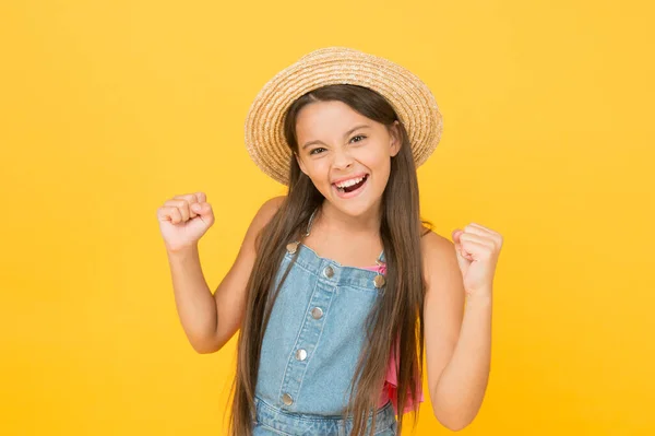 Pasando un gran verano. vacaciones de verano alegre y vacaciones. moda de temporada niño. belleza despreocupada en la pared amarilla. niño sonriente con sombrero de paja. niño pequeño listo para la actividad en la playa. feliz infancia —  Fotos de Stock