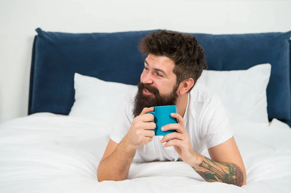 Мужчина счастливый бородатый лицо пить утренний кофе расслабиться в спальне, кофеин концепции дозы — стоковое фото
