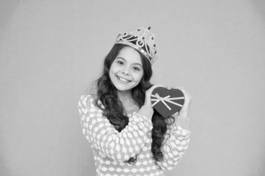 Birincilik ödülüm Sevgiyle hediye. Sevgililer günün kutlu olsun. Kalp şeklinde kutusu olan çocuk. Lüks dünyasına hoş geldin. Küçük prenses. Kız taç takıyor. Ödül konsepti Taç giymiş kız doğum günü hediyesi kutusunu tutuyor.