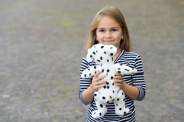 最高のものを選ぶ。屋外でおもちゃの犬と幸せな女の子の遊び。おもちゃ屋さん。ゲームや活動。子供の発達。就学前教育。幼少期に遊ぶ。ベビー用品店。ギフトショップ、コピースペース — ストック写真