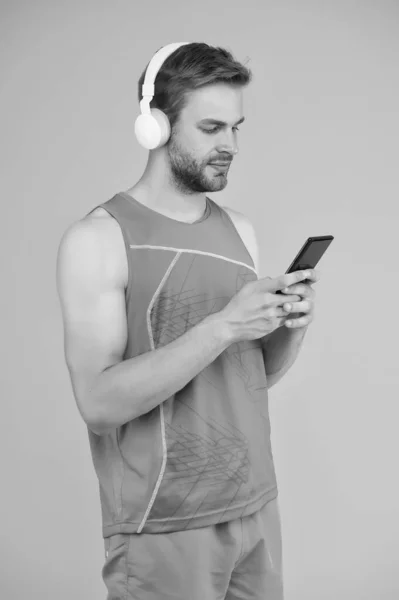 Herhaal na video. Atletische man luister naar muziek smartphone. Workout afspeellijst. Sport en fitness. Gezondheid en welzijn. Trainen motivatie. We volgen de vooruitgang. Aanvraag voor trainingen met online bank — Stockfoto