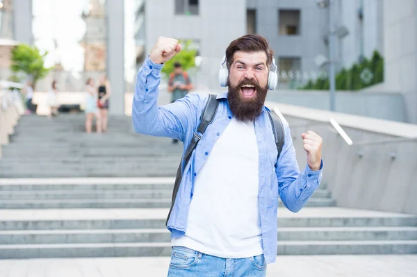 Conceito de energia. Alegria e positividade. Caminho para o trabalho. Sozinho com música. Livre e feliz. Vida moderna. Homem com auscultadores a andar no centro da cidade. A ouvir música. Bonito hipster com mochila. Bom som. — Fotografia de Stock