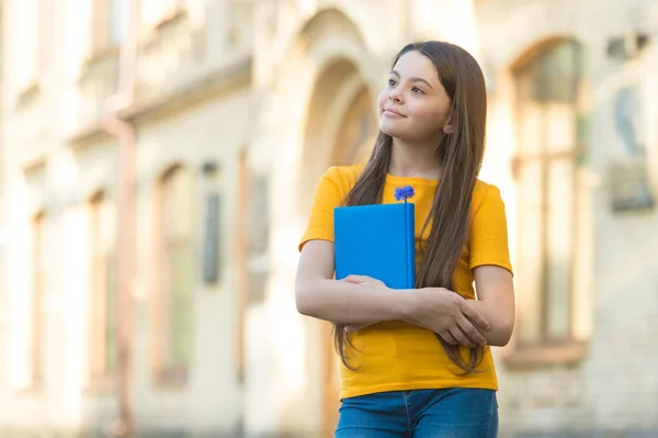 Malá holčička zpět do školy držet učebnice, akademický rok koncept — Stock fotografie