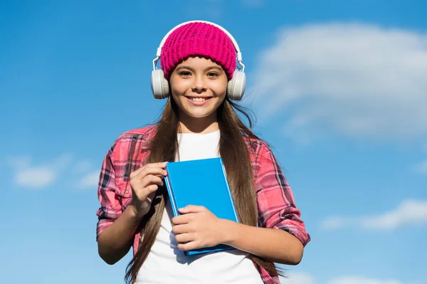 Learn language different way. Happy child wear headphones on blue sky. Audio book. Listening and reading skills. Foreign language school. New technology. Private teaching. Break all language barriers