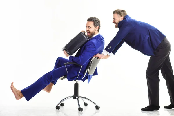 Mann im Anzug oder Geschäftsmann schiebt Bürostuhl mit Kollege — Stockfoto