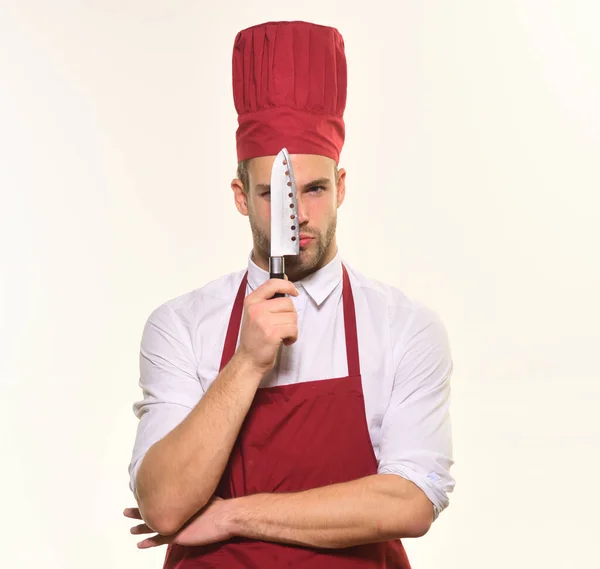 Шеф-кухар в бордовому фартусі і капелюсі тримає гострий ніж . — стокове фото