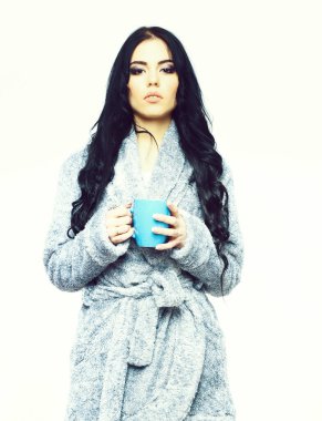 Mavi kadife bornozla fincanla poz veren seksi kız.