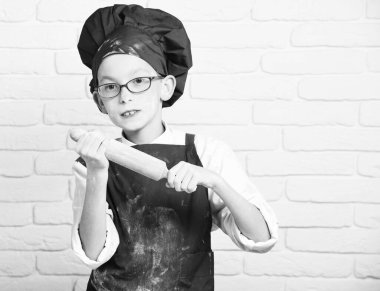 Beyaz tuğla duvarda lekeli aşçı çocuk.