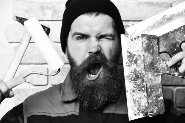 Bearded painter man holding various building tools with satisfied face — Stock Photo, Image