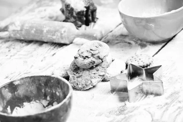 Deliciosas galletas de chocolate en la mesa de madera con mucha harina, enfoque selectivo — Foto de Stock
