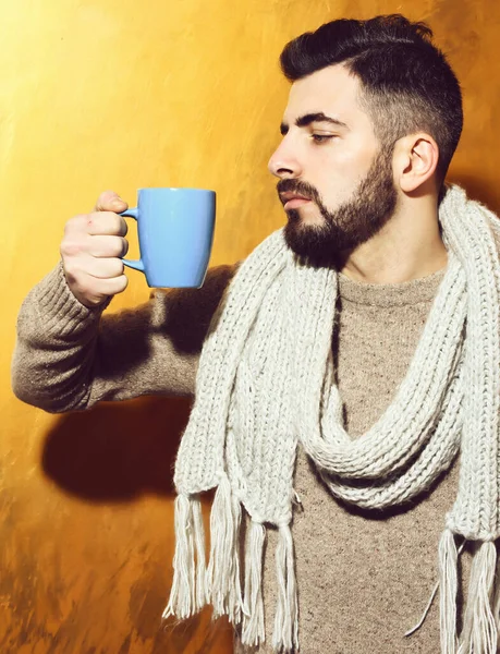 Бородатый мужчина держит чашку чая, кофе с серьезным лицом — стоковое фото