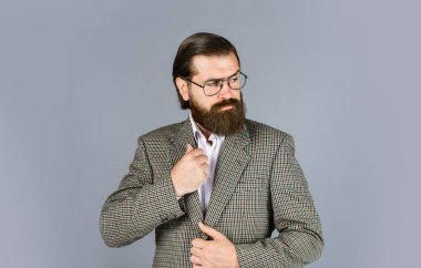 Ciddi sakallı adam. Pahalı takım elbiseli yakışıklı ve başarılı bir adam. O, beyaz gömlek ve gözlük takıyor. Takım elbiseli başarılı bir adam. İş adamı takım elbise giyer. resmi ofis yaşam tarzı