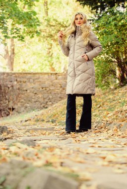 Bu sonbaharda sıcak ve sıcak hissediyorum. Sonbahar sezonu modası. Kız sonbahar yürüyüşünün tadını çıkarıyor. Kadın parkta yürürken ceketini ya da ceketini giyer. Sonbahar yürüyüşü için kıyafet. Elbise dolabı düşmüş olmalı.