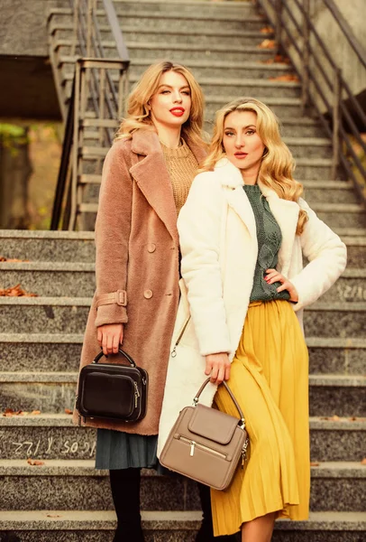 Glamour modellen zien er luxe uit. sexy blong vrouwen. Herfstseizoen. Het moderne leven. Europese winter. Meisjes warme jas op de trap. Valse bontjas mode. stijlvolle business dames leren tas — Stockfoto