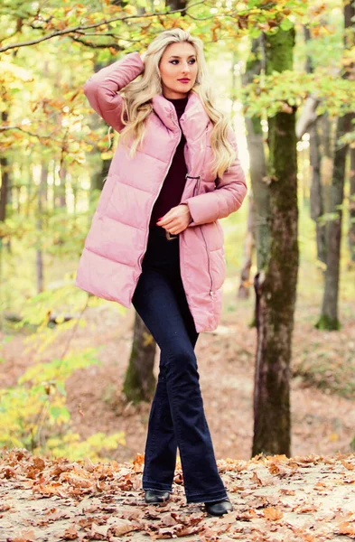 Meisje modieuze blonde lopen in de herfst bos. Jassen die iedereen zou moeten hebben. Beste kogeljassen om te kopen. Hoe je een kogelvrij vest moet dragen als een ster. Kogelvrij modeconcept. Vrouw draagt warm roze jasje — Stockfoto