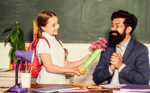 Menina aluno adorável com mochila dando professor de flores de buquê. De volta à escola. Felicidades. Parabéns pelo dia do conhecimento. Saudações para o pedagogo da escola. Férias escolares. Grato colegial — Fotografia de Stock