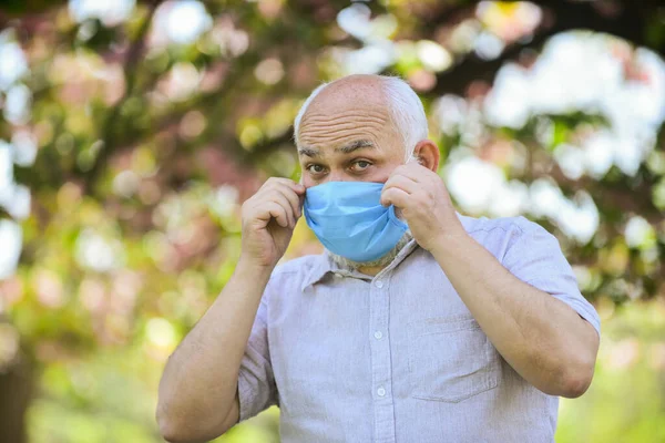 Quero apagá-lo. usar máscara no parque florescente. homem ao ar livre em máscara protetora. cheirar flores florescendo em quarentena coronavírus. observar precauções durante a pandemia. vida saudável — Fotografia de Stock