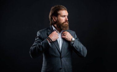 İş adamı takım elbise giyer. Resmi ofis hayatı. Ciddi sakallı adam. Pahalı takım elbiseli yakışıklı adam. Saati olan bir gömlek. Takım elbiseli başarılı bir adam. Smokin modası.