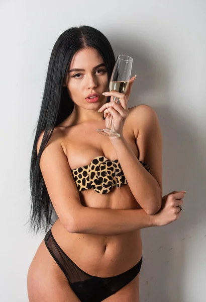 Be brave and take risk. wild and glam. sexy female boobs pulled together by belt. Beautiful model girl in trendy belt drink champagne. leopard printed belt. Stylish leopard belt for real woman — Stock Photo, Image