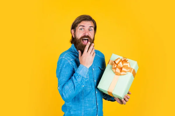 making purchases at store. buy anniversary gifts. surprised male open box with something exciting inside. mature man looking casual in surprise with present gift box. commonly used for birthday