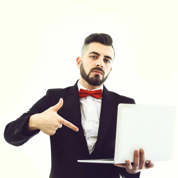 Succesvolle zakenman met baard en serieuze gezichtspunten op laptop — Stockfoto